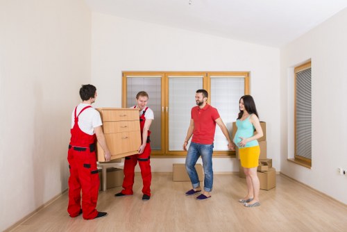 Man and van team safely moving furniture with protective handling equipment